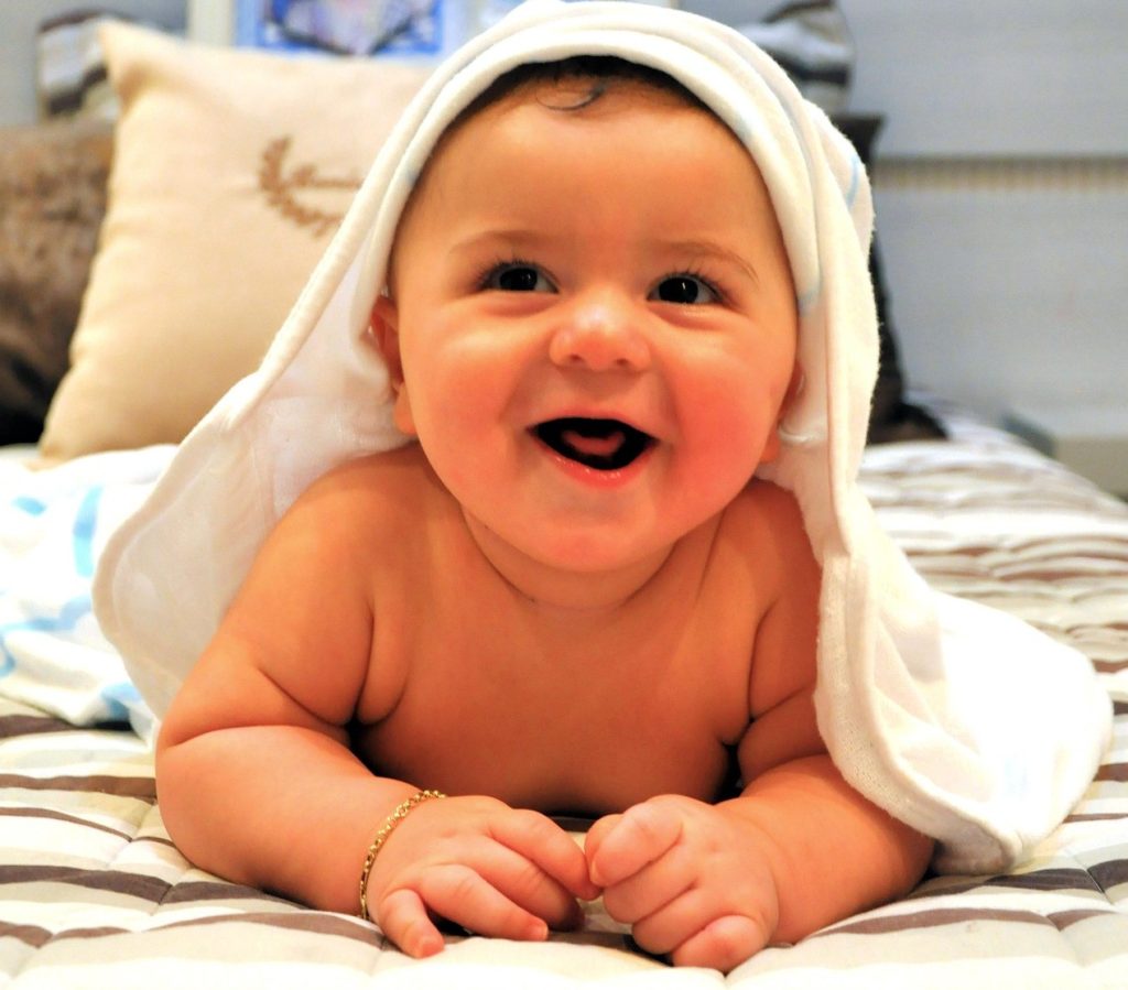 کودک خندان با پلاک طلا در دست راست